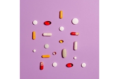 Image Lots of pretty colored pills on a lavender background.